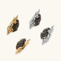Sculptural gold-toned earrings with textured coral-like design, rhinestone accents, and black volcanic stone elements.