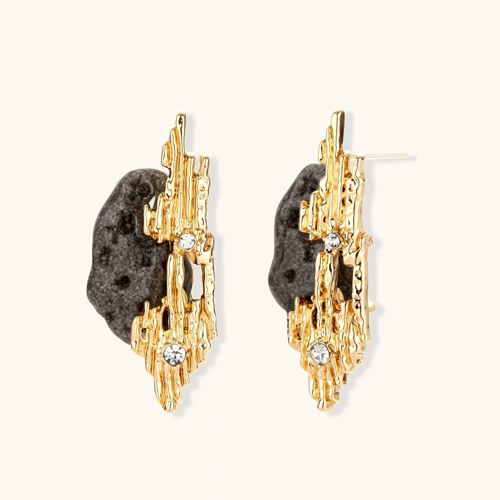 Sculptural statement earrings with textured volcanic stones and flowing silver metal design with crystal accents